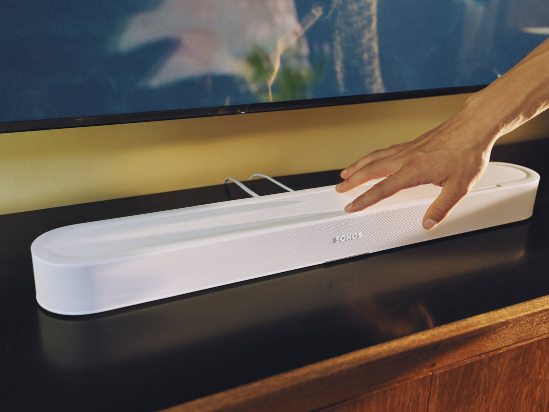 A hand using the touch controls on top of the soundbar
